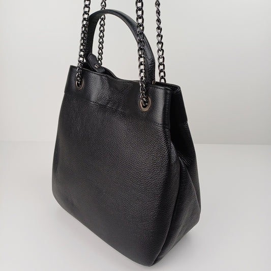 The bag has a soft, slouchy shape and is presented on a light surface.