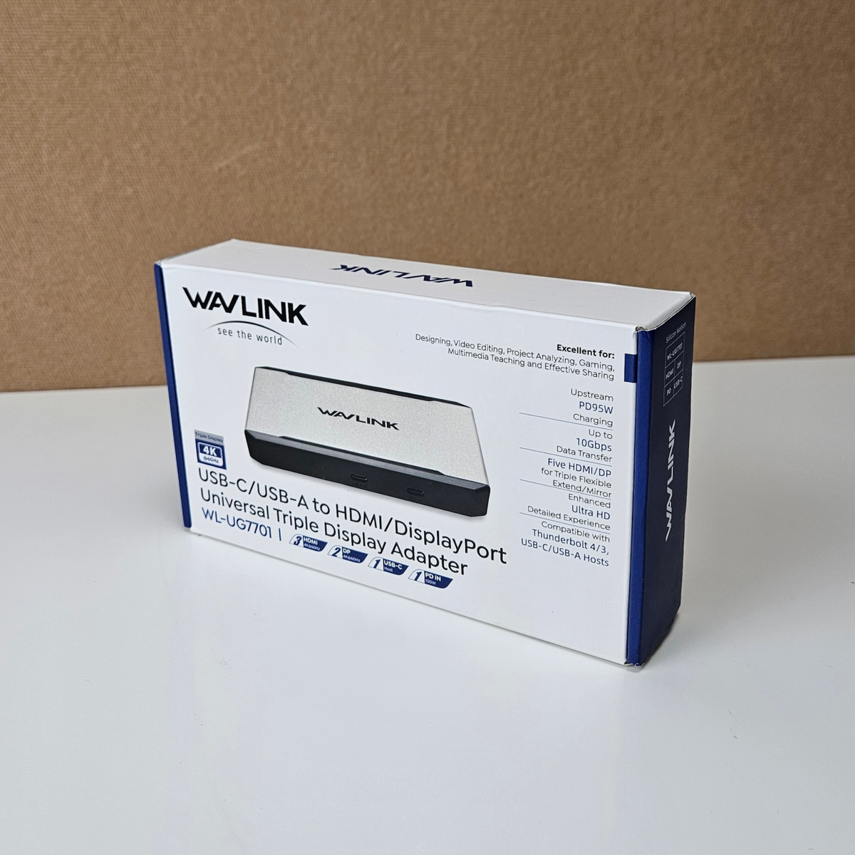 Wavlink WL-VG7901 USB-C to HDMI/DisplayPort universal triple display adapter retail box, shown standing on a white surface against a brown cardboard background.