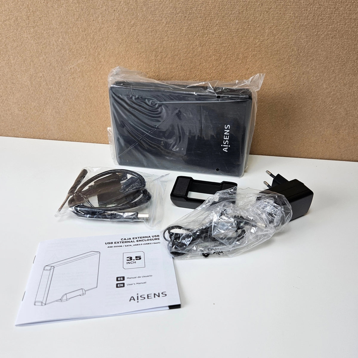 Unboxed AISENS 3.5-inch hard drive enclosure kit with cables, power adapter, and manual