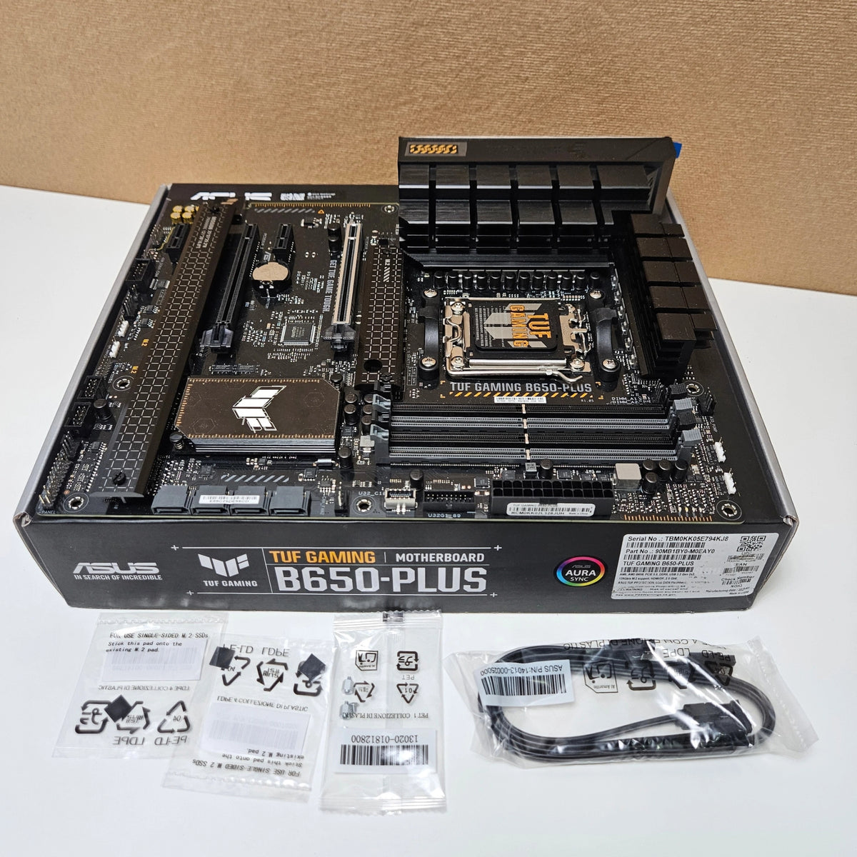 Top-down view of the motherboard laid out with its included installation accessories