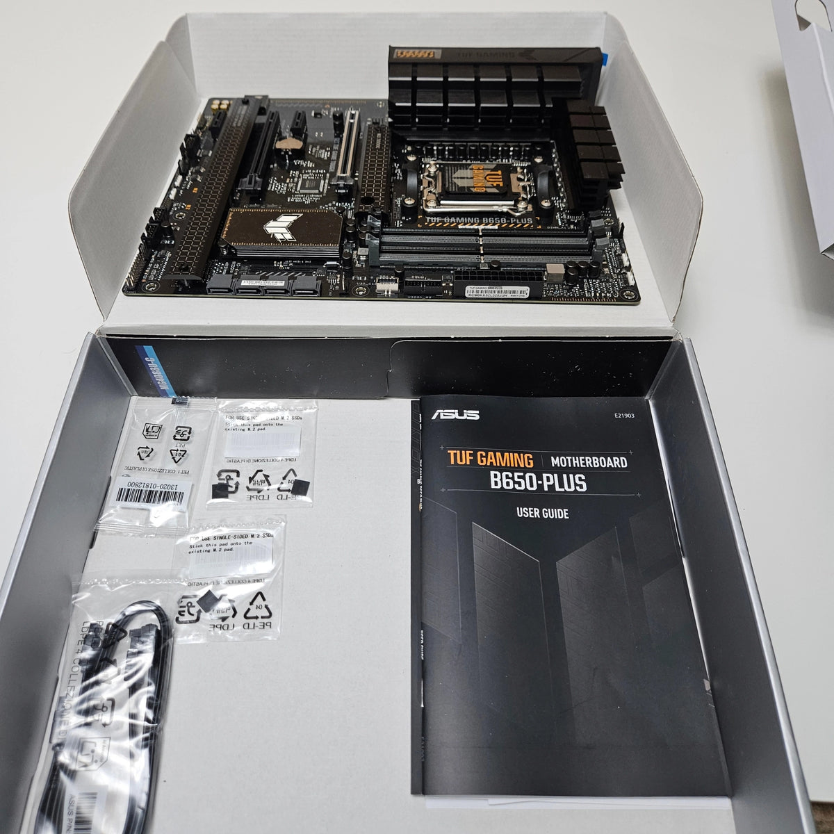  Unboxed ASUS TUF Gaming B650-PLUS motherboard with user manual and cables