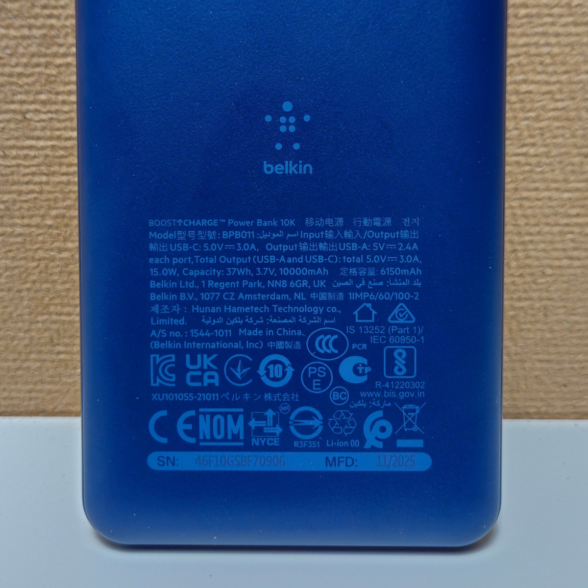 Back of a blue Belkin portable battery with product information.