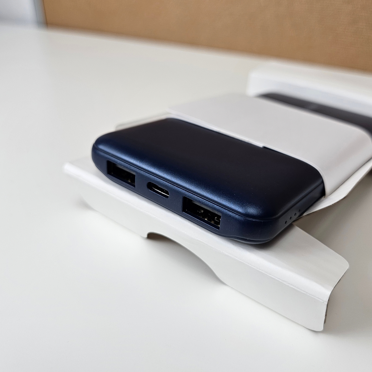 Blue Belkin portable charger on a desk.