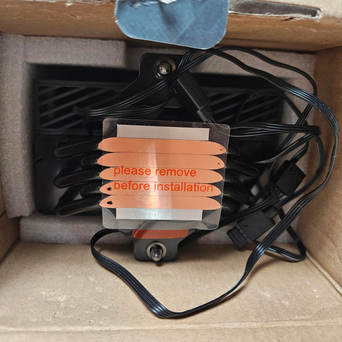 Close-up of the warning sticker on the copper heatpipe base inside the box