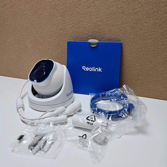 White Reolink dome camera displayed with included mounting screws, network cable, and manual.