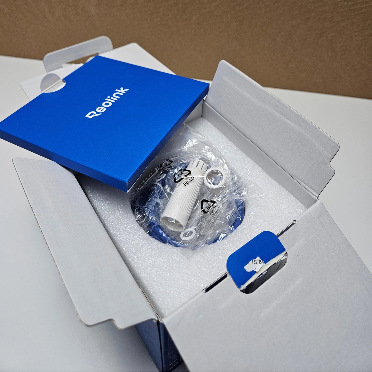 Top-down view of the inside of the Reolink cardboard box showing neat packaging layout.