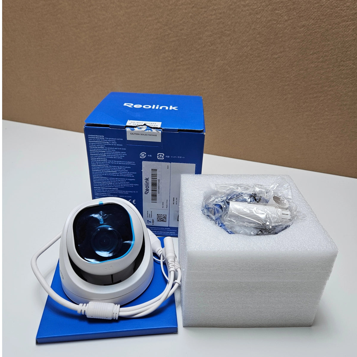 Reolink RLC-820A camera with its original blue packaging box, foam insert, and accessories.